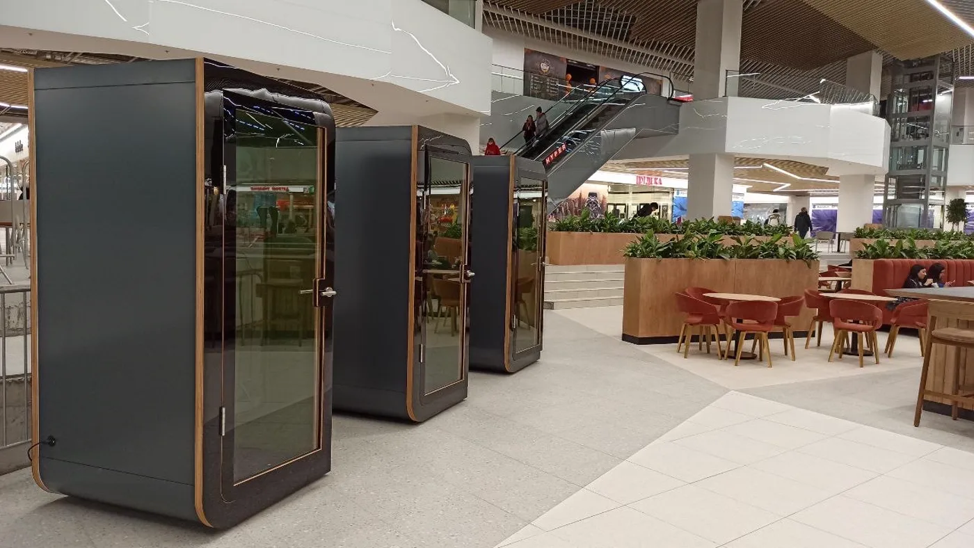 A row of Silentbox acoustic booths by the escalator in the Karavan mall, Kharkiv