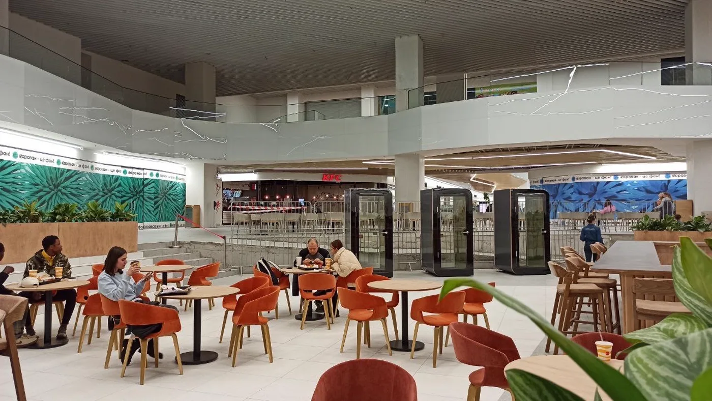 Silentbox acoustic booths in the food-court area with visitors, Karavan mall, Kharkiv