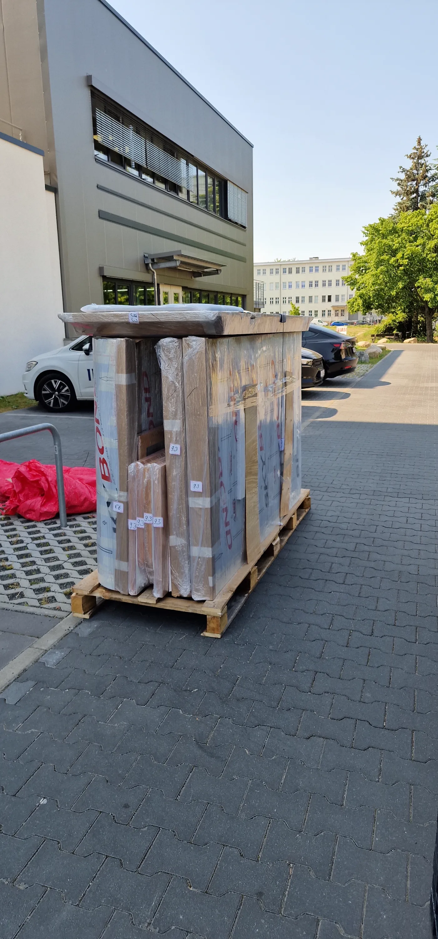 Silentbox acoustic booth sections wrapped in protective film on a wooden pallet, ready for dispatch